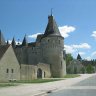 Château de Fougères-sur-Bièvre. La tour d'angle ouest  vue du village et en arrière-plan l'église Saint-Eloi (XIIe siècle)